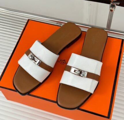 Hermès women's slippers in white and brown with a metallic buckle detail