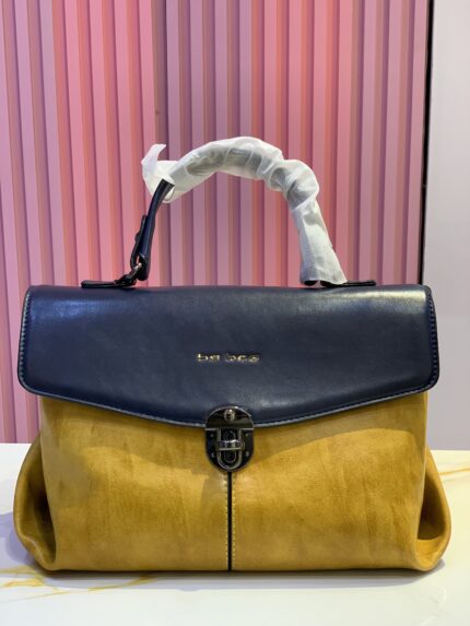 two-tone top-handle leather handbag, featuring a navy blue flap closure and a yellow body
