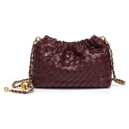 Woven faux leather crossbody bag with a chain strap in a burgundy or wine color